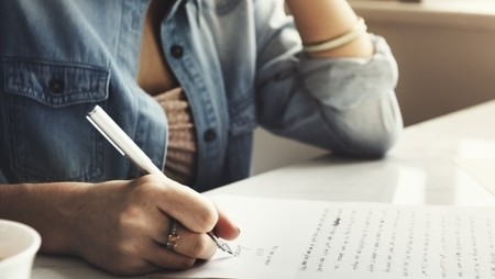 woman writing cover letter with pen