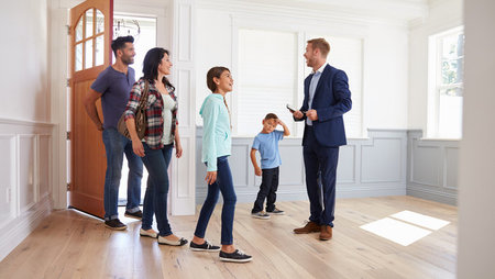 Male real estate agent showing a house to a young family