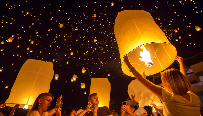 People releasing lanterns into the sky during Yi Peng