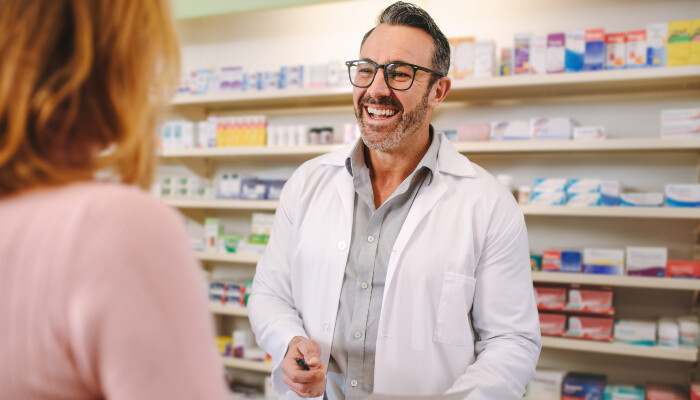 A male pharmacist dealing with a female customer